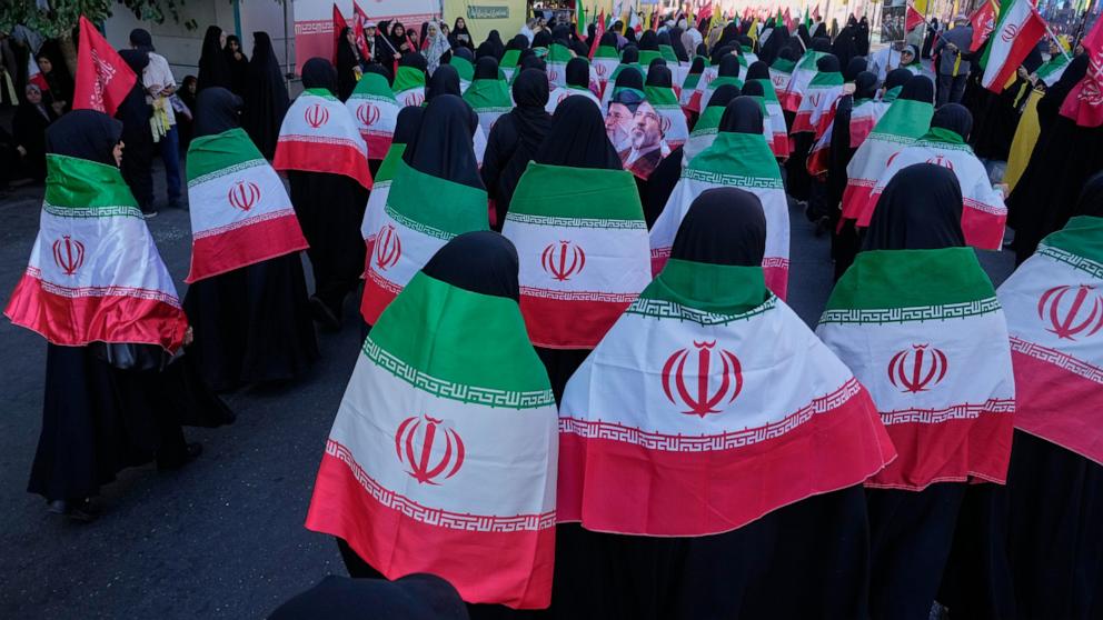 PHOTO: Women draped in Iranian flags march during the state-organized "Janfada," or "Sacrifice for Iran," military-style parade in Tehran, Iran, Sept. 18, 2026.