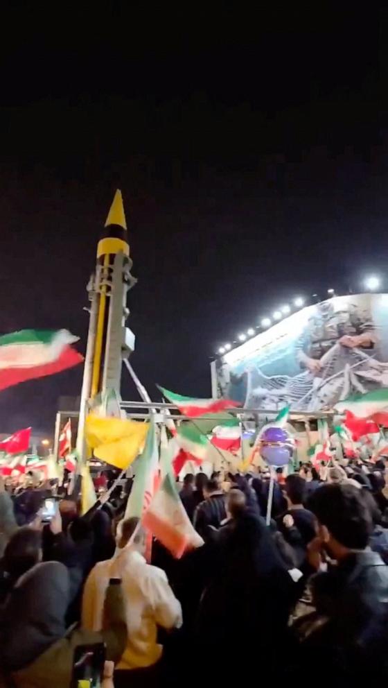 PHOTO: People wave Iranian flags as the military displays a missile in Tehran, Iran, on April 21, 2026.