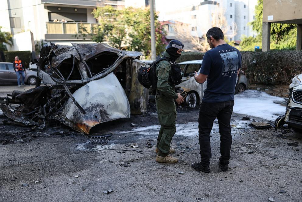 PHOTO: Israeli security forces stand next to the wreckage of cars in Ramat Gan near Tel Aviv on March 3, 2026.