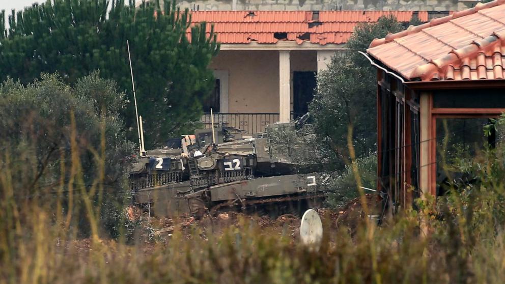 PHOTO: This picture shows an Israeli army tank stationed between houses in Lebanon southern village of Khiam on Nov. 27, 2024.