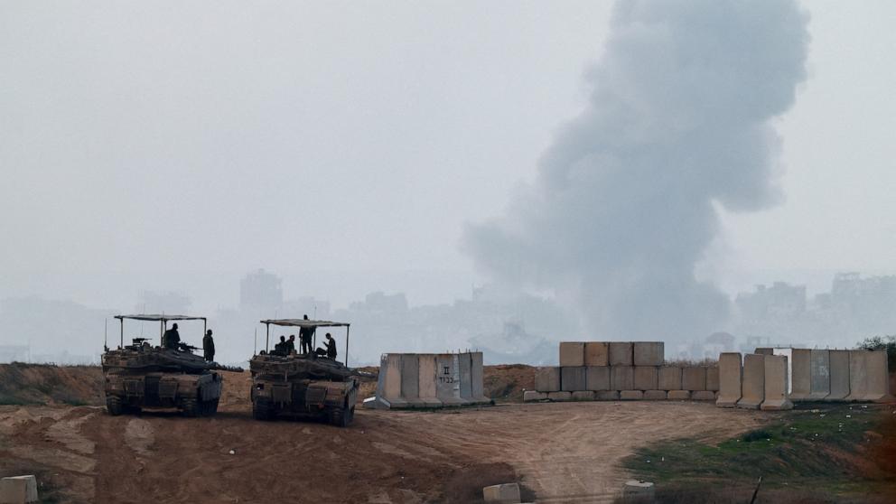 PHOTO: Israeli tanks are pictured as smoke from an airstrike rises over Gaza, as seen from Israel on Dec. 22, 2024.