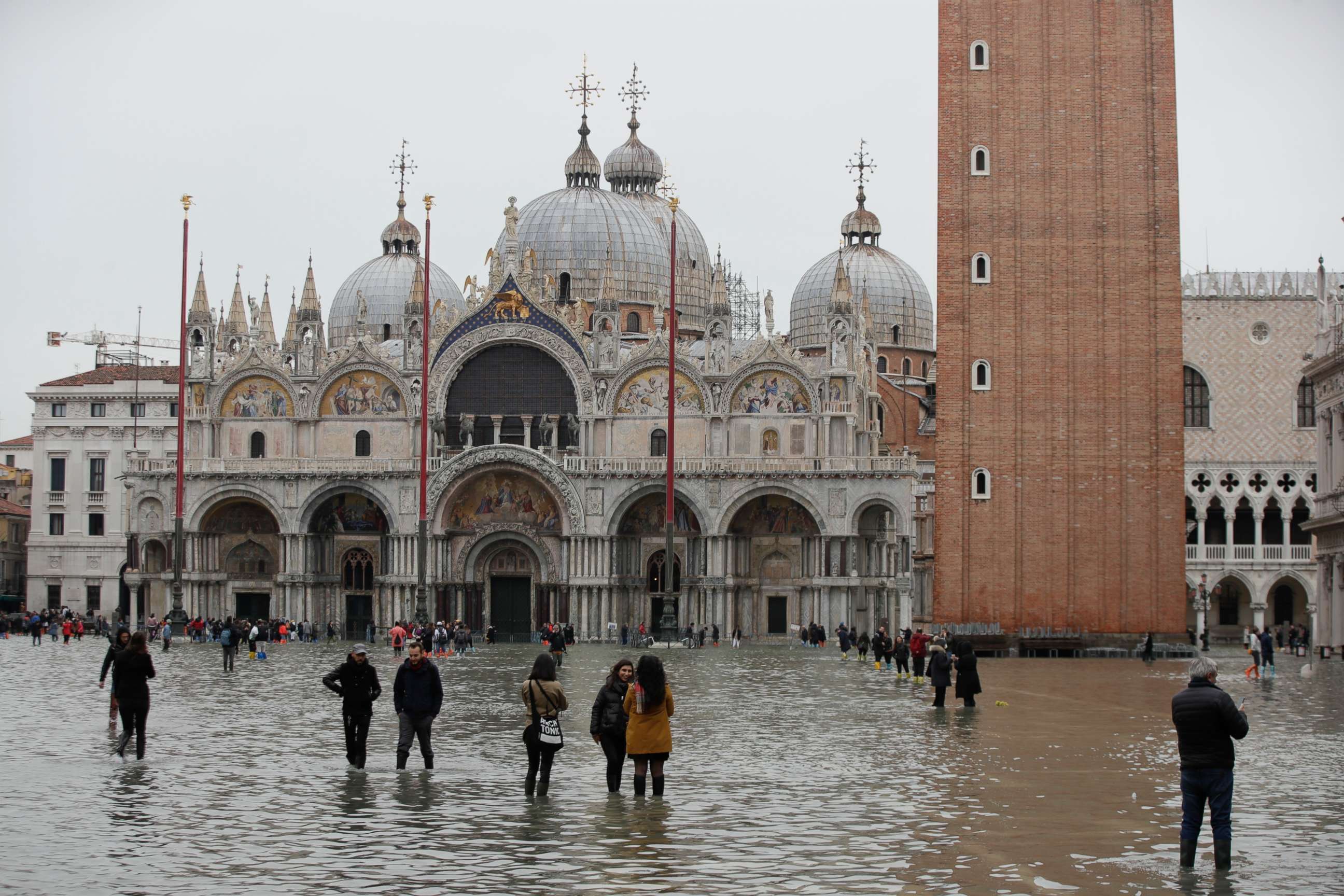 PHOTO: People wade through water in a flooded St. Mark's Square, in Venice, Wednesday, Nov. 13, 2019. The high-water mark hit 187 centimeters (74 inches) late Tuesday, Nov. 12, 2019, meaning more than 85% of the city was flooded. (AP Photo/Luca Bruno)