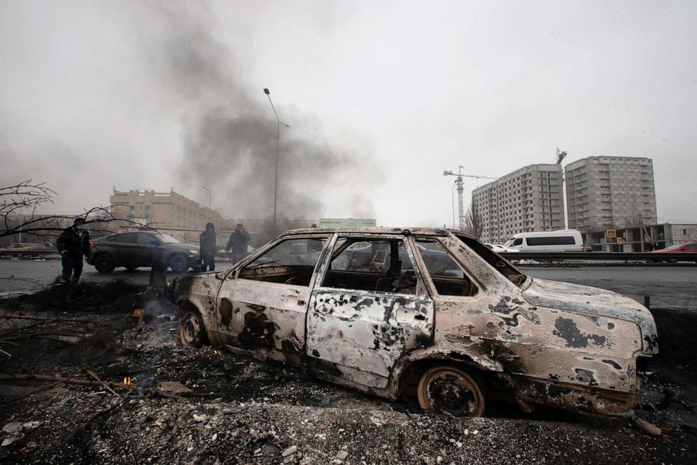 FOTO: Ein Auto, das nach Zusammenstößen verbrannt wurde, wird am 7. Januar 2022 auf einer Straße in Almaty, Kasachstan, gesehen.