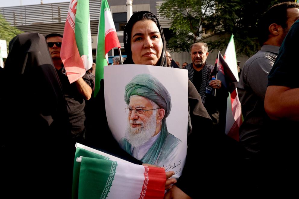 PHOTO: A mourner holds up a poster showing the images of Iran's Supreme Leader Ali Khamenei during the funeral of Iranian commanders killed during Israeli strikes on Iran in the capital Tehran on June 28, 2025.