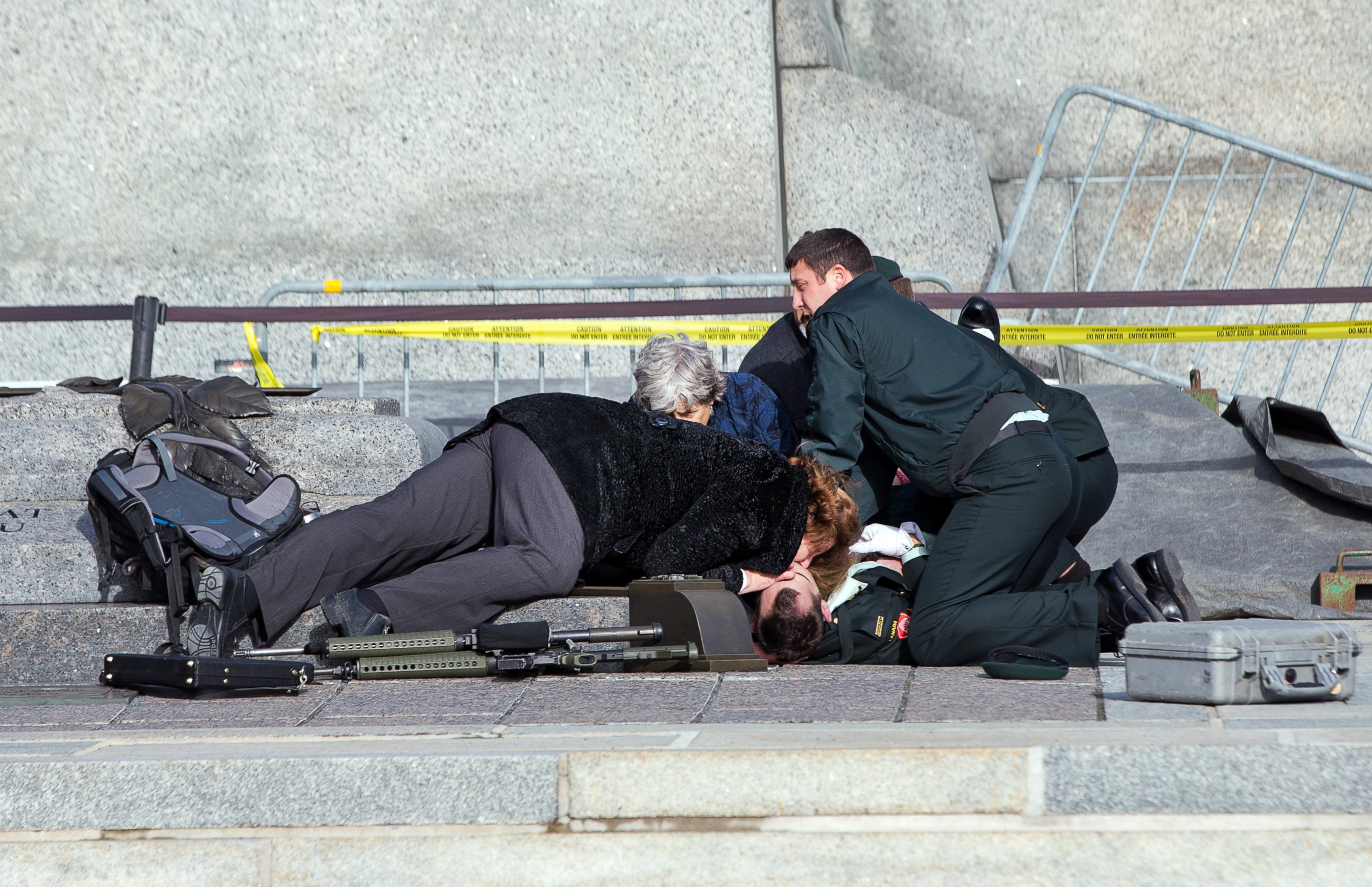 PHOTO: Police, bystanders and soldiers aid a fallen soldier at the War Memorial as police respond, Oct. 22, 2014 in Ottawa.