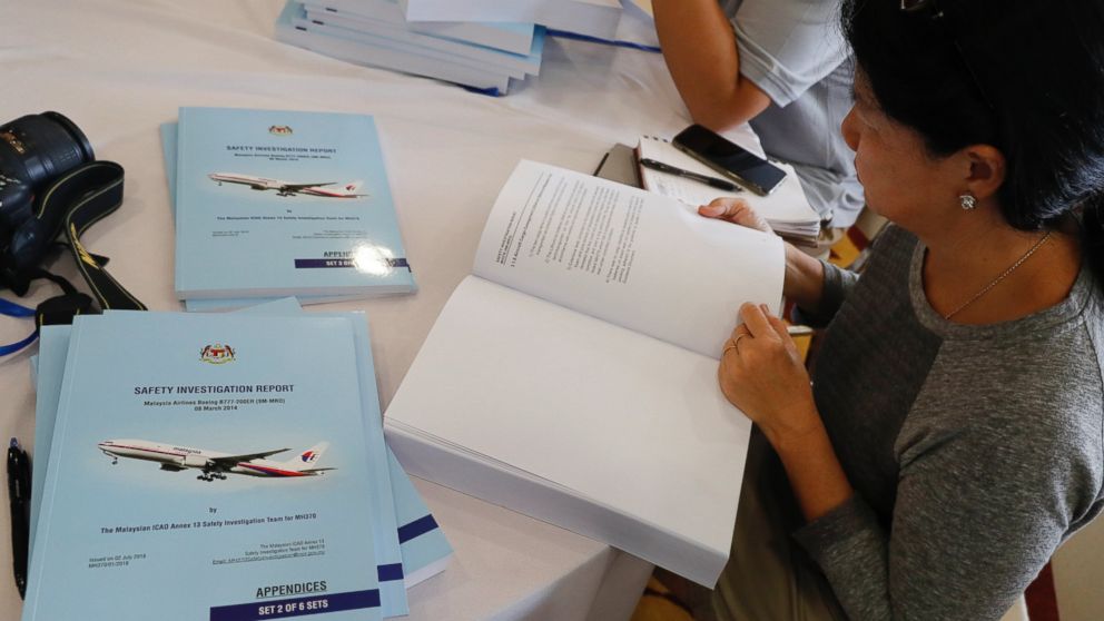 Copies of the final investigation report on missing flight MH370 are offered to the media in Putrajaya, Monday, July 30, 2018.