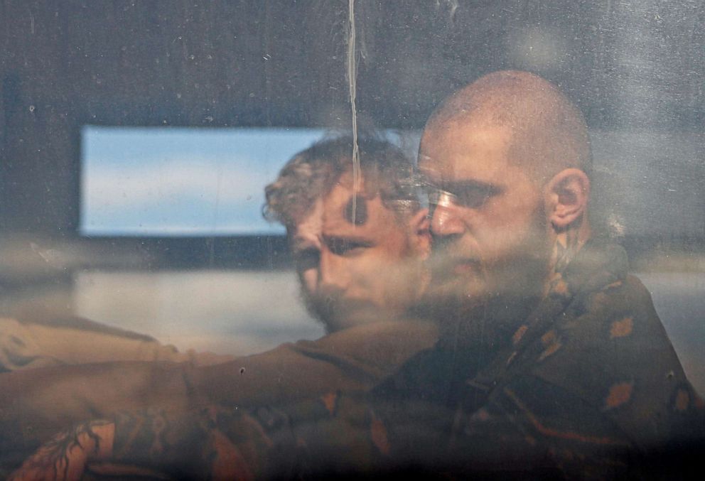 PHOTO: Service members of Ukrainian forces who have surrendered after weeks holed up at Azovstal steel works are seen inside a bus driving away under escort of the pro-Russian military in Mariupol, Ukraine, May 17, 2022. 