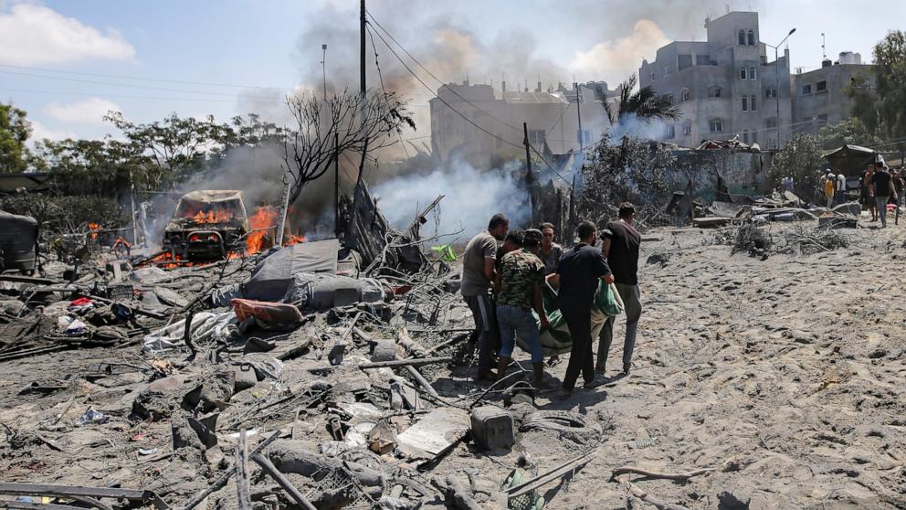 PHOTO: Palestinians evacuate a body from a site hit by an Israeli bombardment on Khan Younis, southern Gaza Strip, on July 13, 2024.