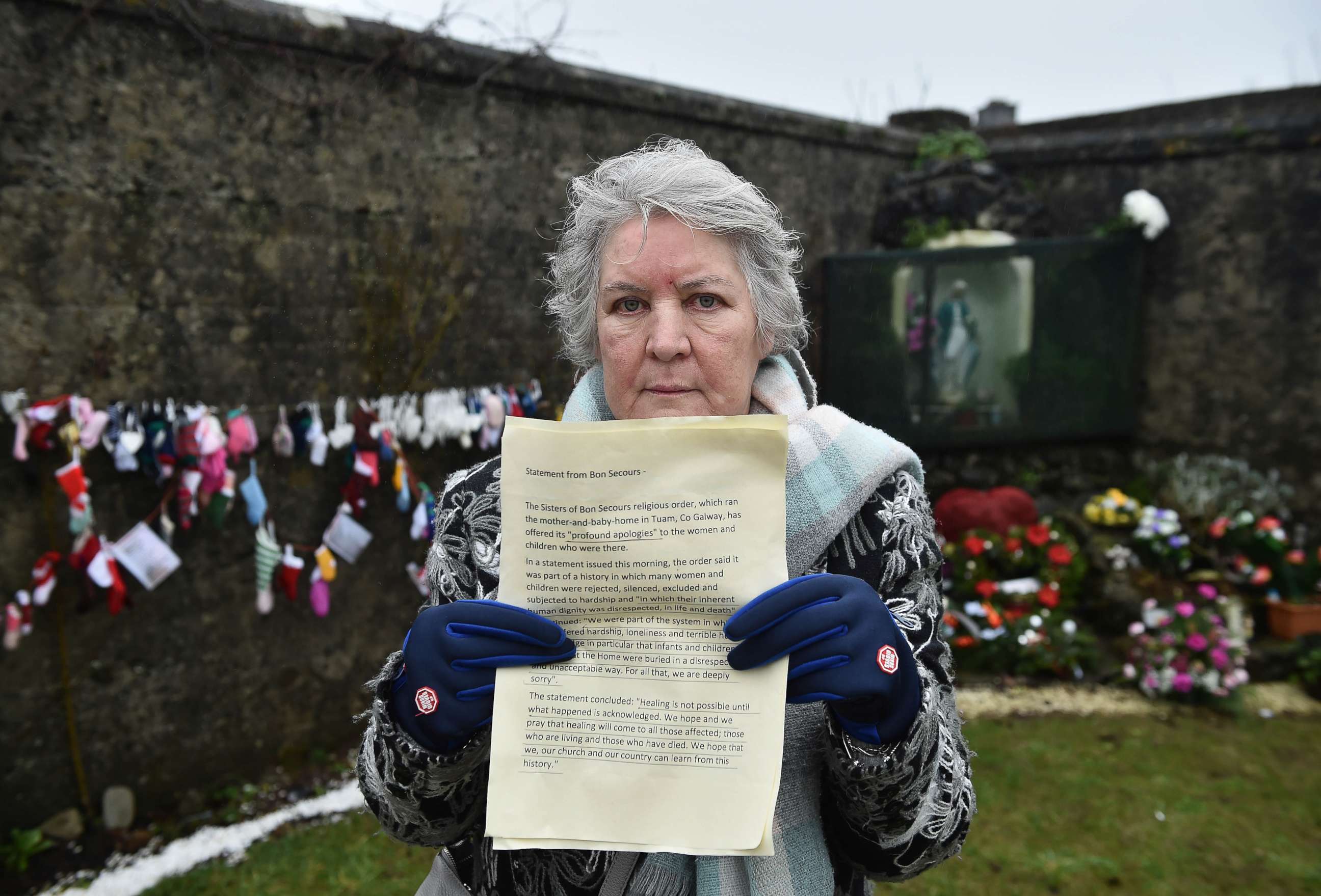 PHOTO: TUAM, IRELAND - JANUARY 13: Tuam Mother and Baby Home survivor, Carmel Larkin holds an apology issued today by the Bon Secours order of nuns as she visits the shrine which stands on a mass burial site on January 13, 2021 in Tuam, Ireland. 