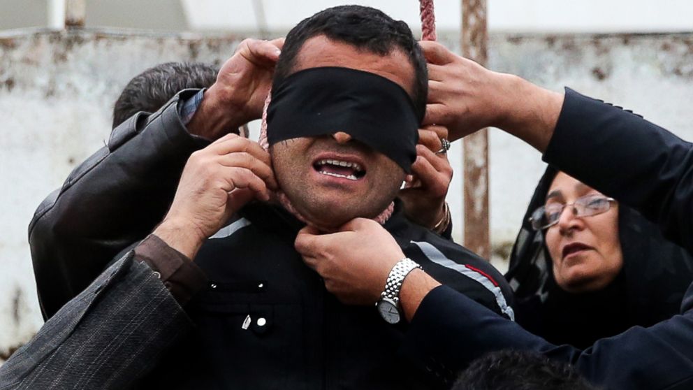 The mother, right, of Abdolah Hosseinzadeh, who was murdered in 2007, removes the noose with the help of her husband from around the neck of Balal, who killed her son, during the execution ceremony in Nowshahr, April 15, 2014, sparing the life of her son's convicted murderer.