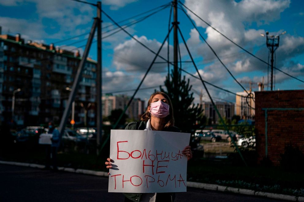PHOTO: (FILES) In this file photo taken on August 21, 2020 a woman holding a placard reading "A hospital is not a prison" stands outside Omsk Emergency Hospital No. 1 where Alexei Navalny was admitted after he fell ill. 
