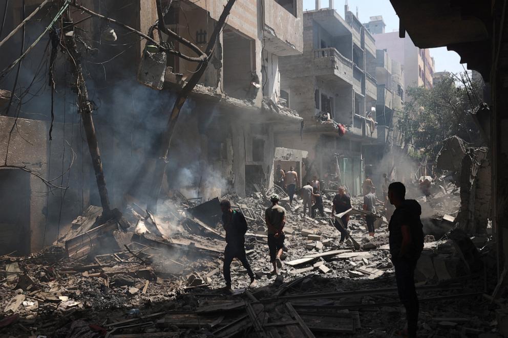 PHOTO: Palestinians walk on the rubble of destroyed buildings following an operations by the Israeli Special Forces in the Nuseirat camp, in the central Gaza Strip on June 8, 2024,.