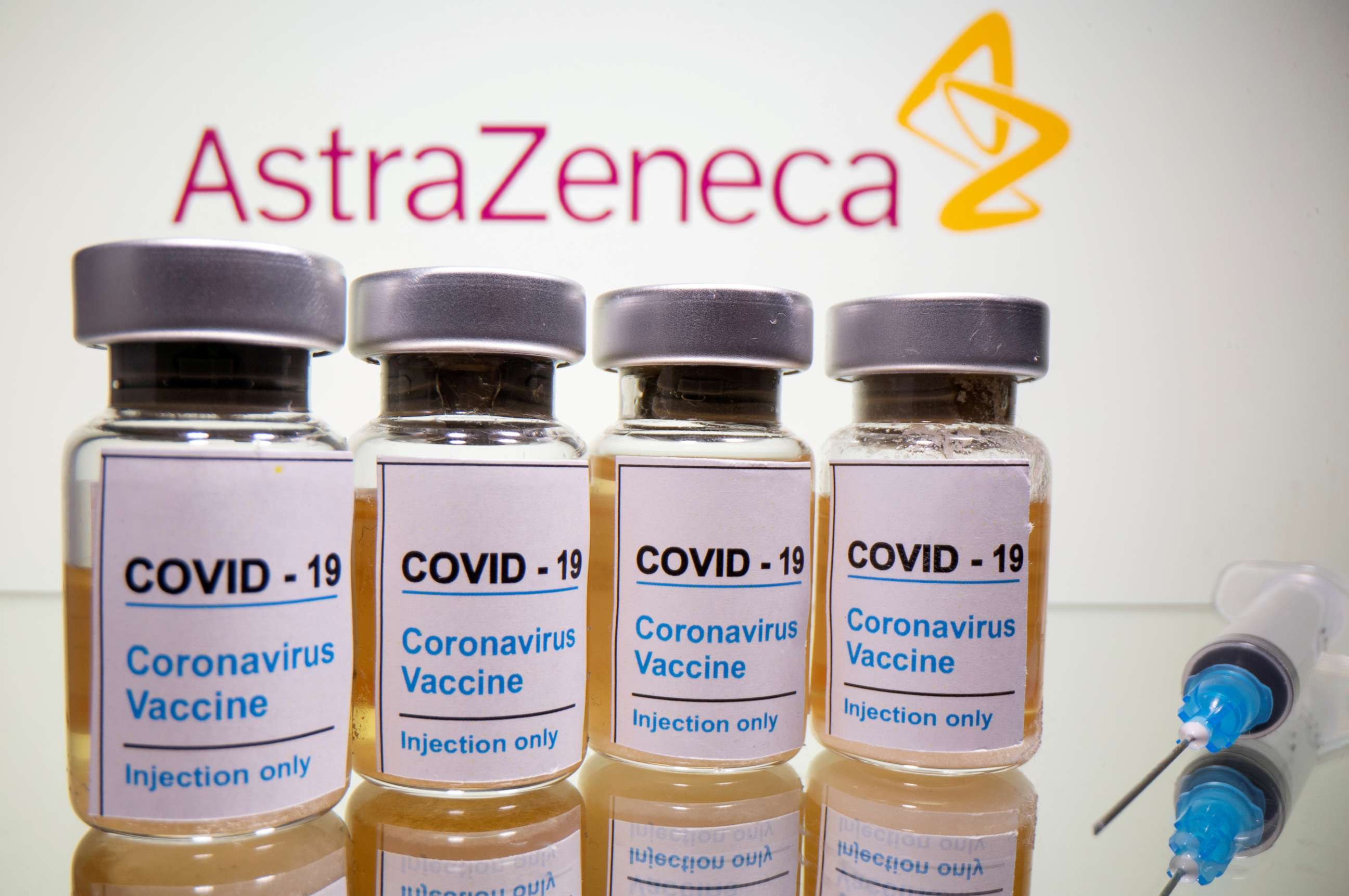 FILE PHOTO: Vials with a sticker reading, "COVID-19 / Coronavirus vaccine / Injection only" and a medical syringe are seen in front of a displayed AstraZeneca logo in this illustration taken October 31, 2020. 