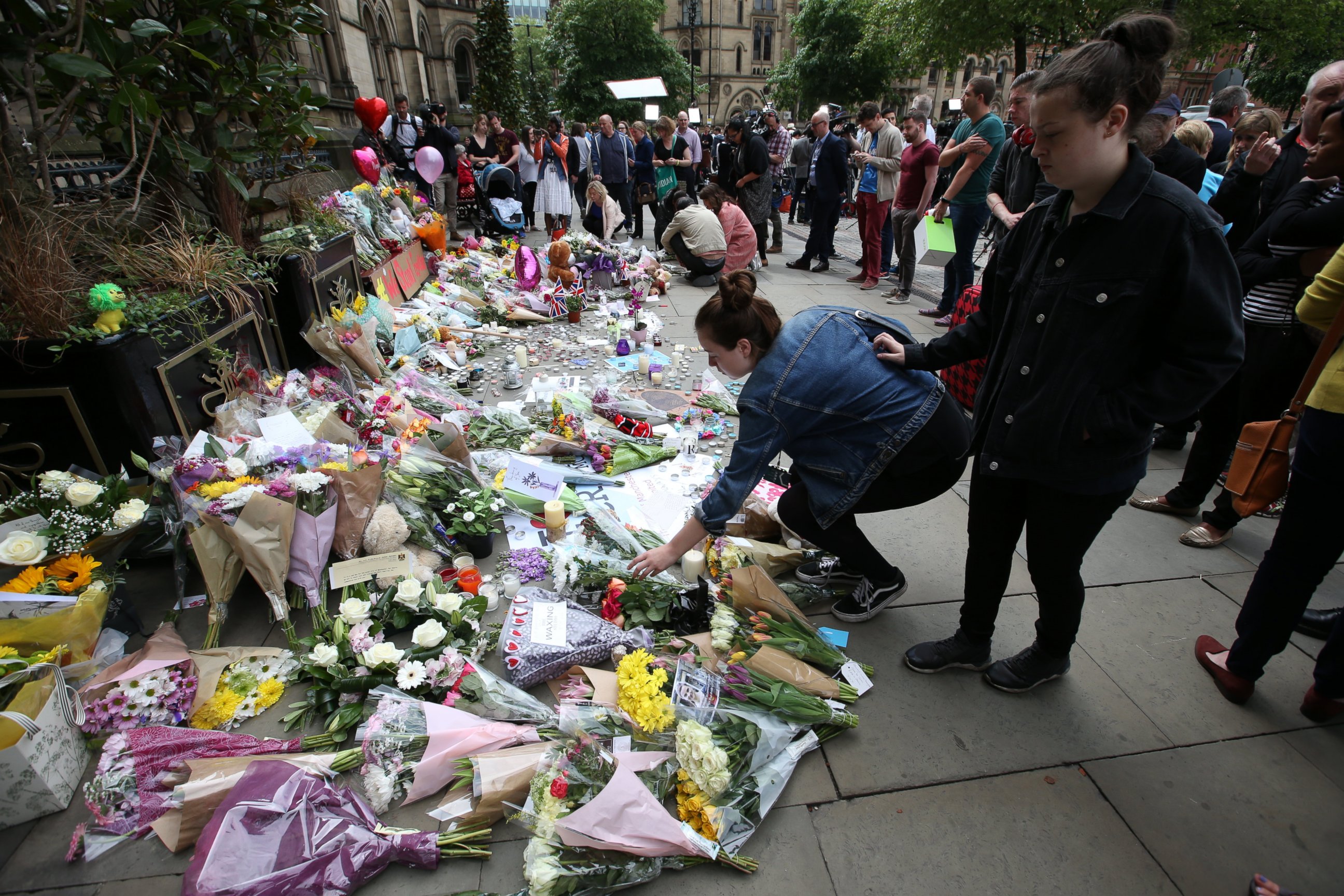 PHOTO: People at Albert Square in Manchester, UK look at the growing amount of floral tributes for the victims of the Manchester terror attack.
