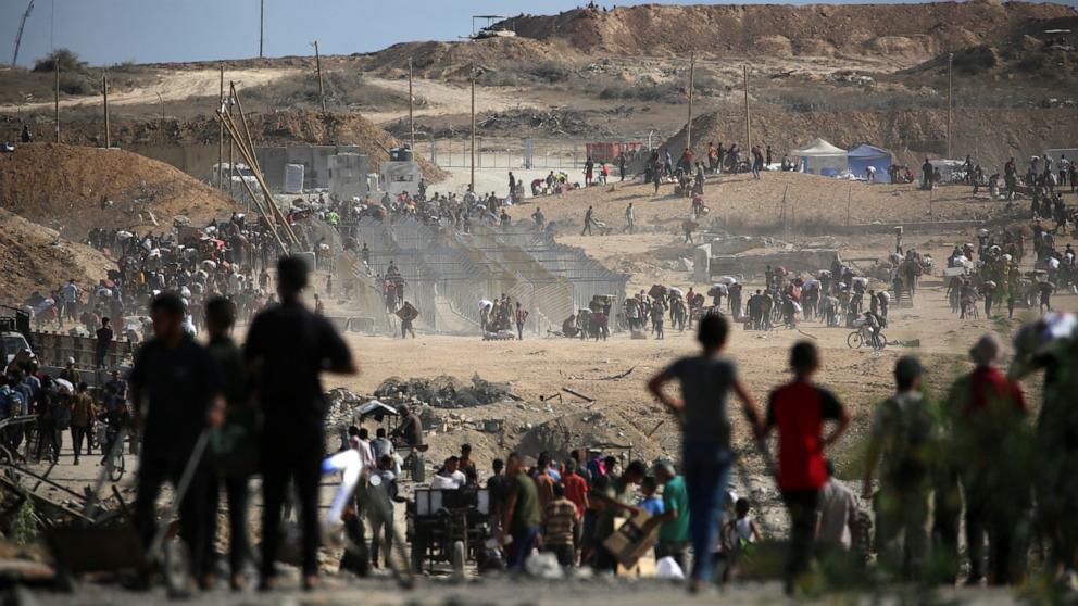 PHOTO: Palestinians carrying bags return from a food distribution point near the Netzarim corridor in the central Gaza Strip on Oct. 5, 2025.
