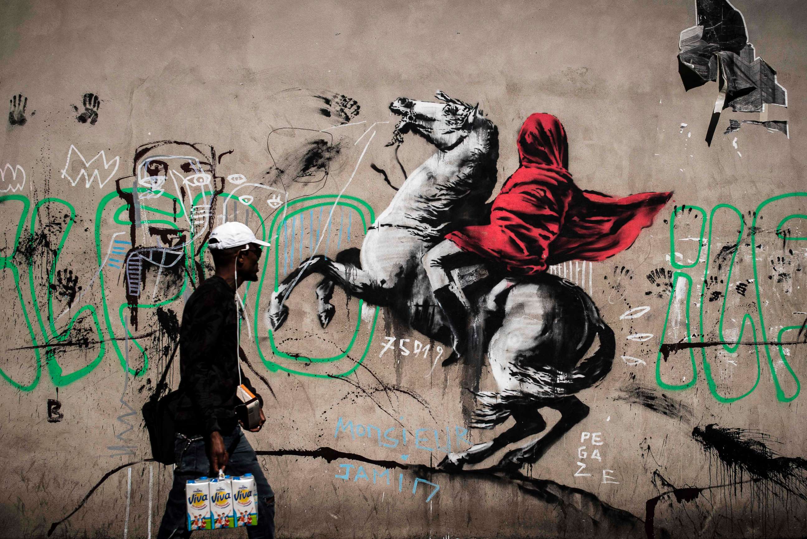 PHOTO: A man walks past a recent artwork by street artist Banksy in Paris on June 25, 2018. The  street artist's artwork of Napoleon Bonaparte wearing a headscarf inspired by the original painting by Jacques-Louis David was found in northern Paris.
