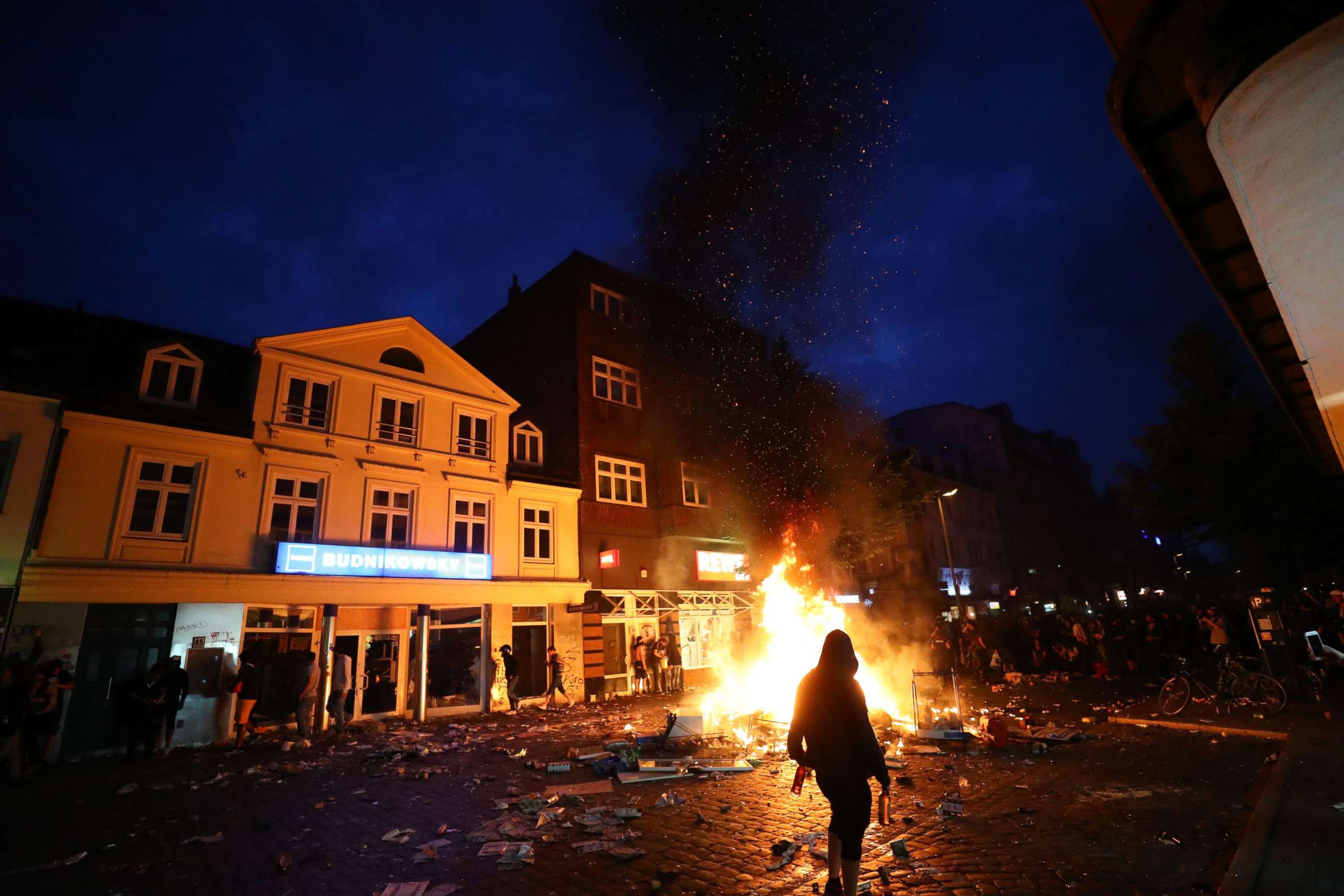 PHOTO: A protester walks past burning barricades during the protests at the G20 summit in Hamburg, Germany, July 7, 2017.