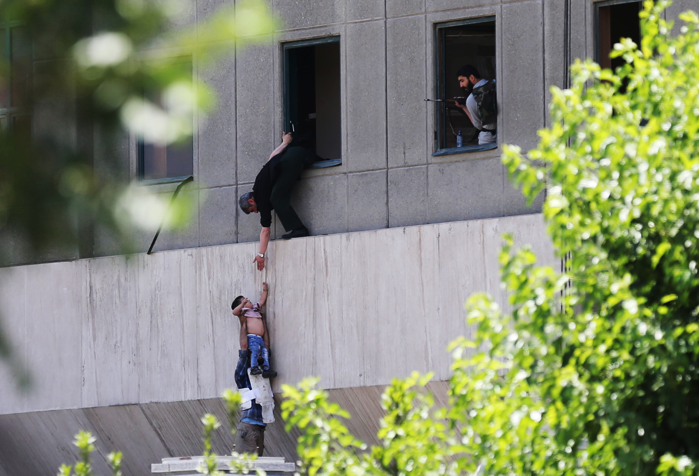 PHOTO: A boy is evacuated during an attack on the Iranian parliament in central Tehran, Iran, June 7, 2017.