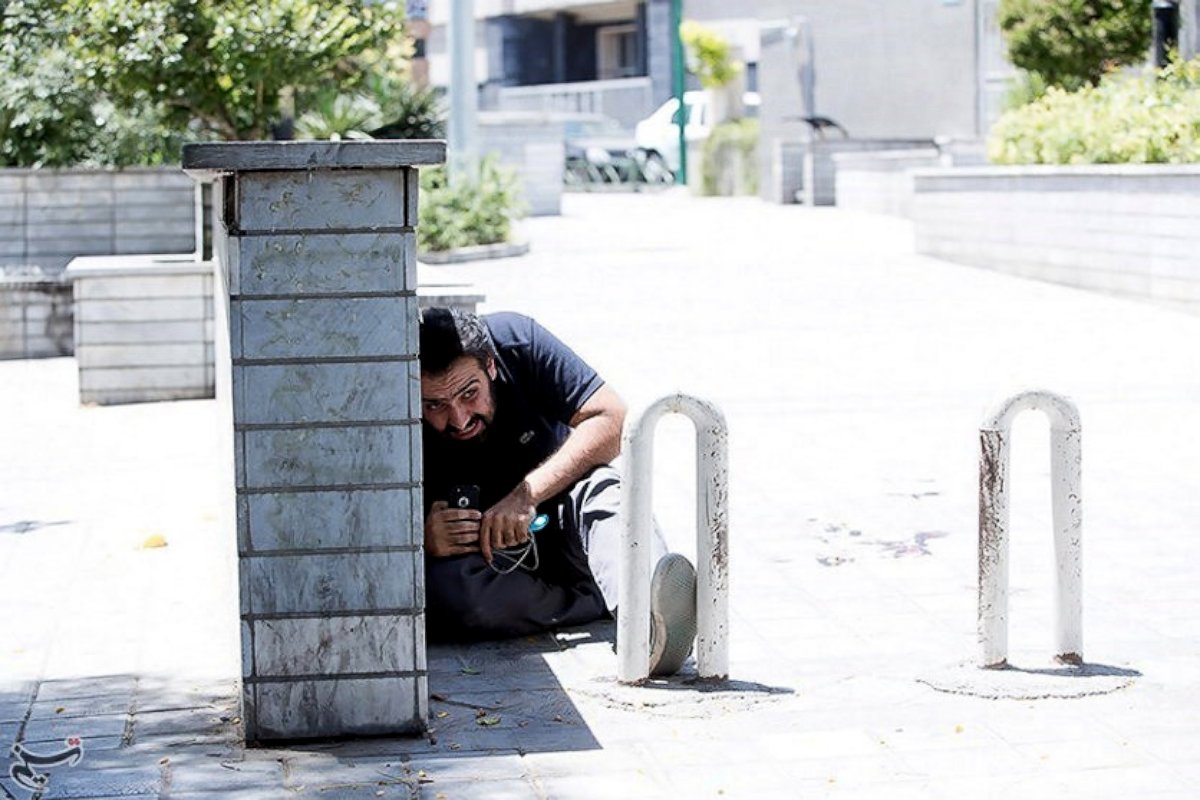 PHOTO: A man takes cover during an attack on the Iranian parliament in central Tehran, Iran, June 7, 2017. 