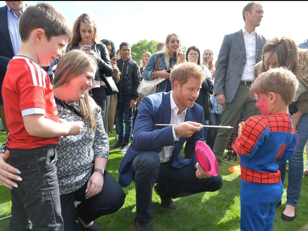 PHOTO: Britain's Prince Harry talks to children at a tea party at Buckingham Palace in London, May 13, 2017. 