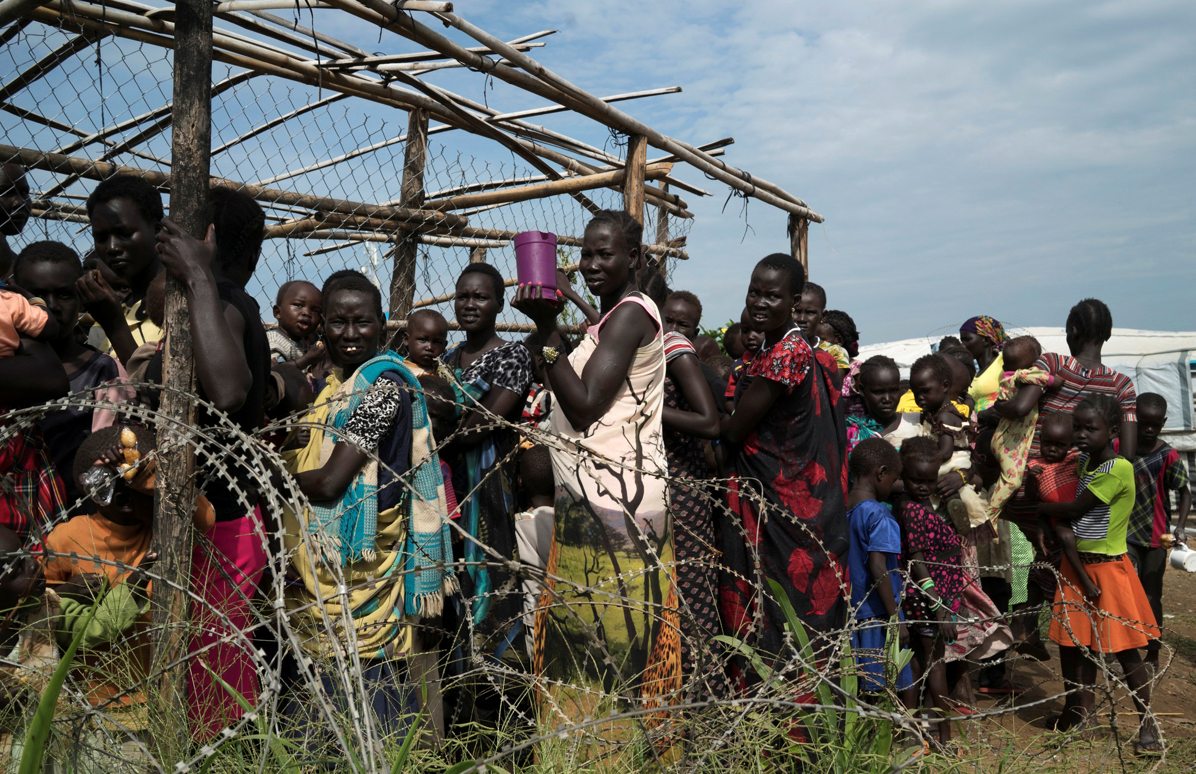 PHOTO: South Sudanese women and children queue to receive emergency food at the United Nations protection of civilians (POC) site 3 hosting about 30,000 people displaced during the recent fighting in Juba, South Sudan, July 25, 2016. 