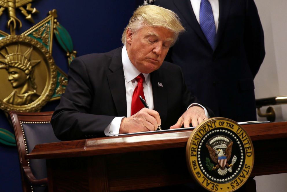 PHOTO: President Donald Trump signs an executive order to impose tighter vetting of travelers entering the United States, at the Pentagon, Jan. 27, 2017. 