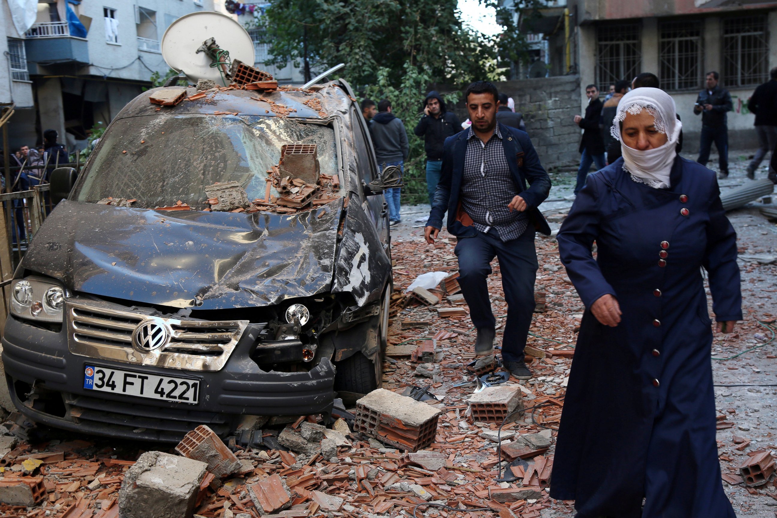 PHOTO: People walk past a damaged car after a blast in the Kurdish-dominated southeastern city of Diyarbakir, Turkey, Nov. 4, 2016.