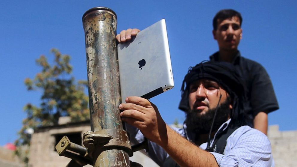 A member of the "Ansar Dimachk" Brigade, which operates under the Free Syrian Army, uses an iPad during preparations to fire a homemade mortar at one of the battlefronts in Jobar, Damascus, Syria, Sept. 15, 2013.