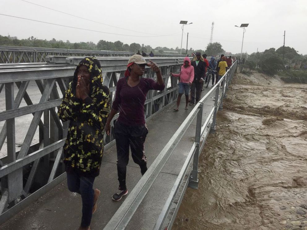 PHOTO: People cross a bridge while Hurricane Matthew passes in Port-au-Prince, Haiti, Oct. 4, 2016.