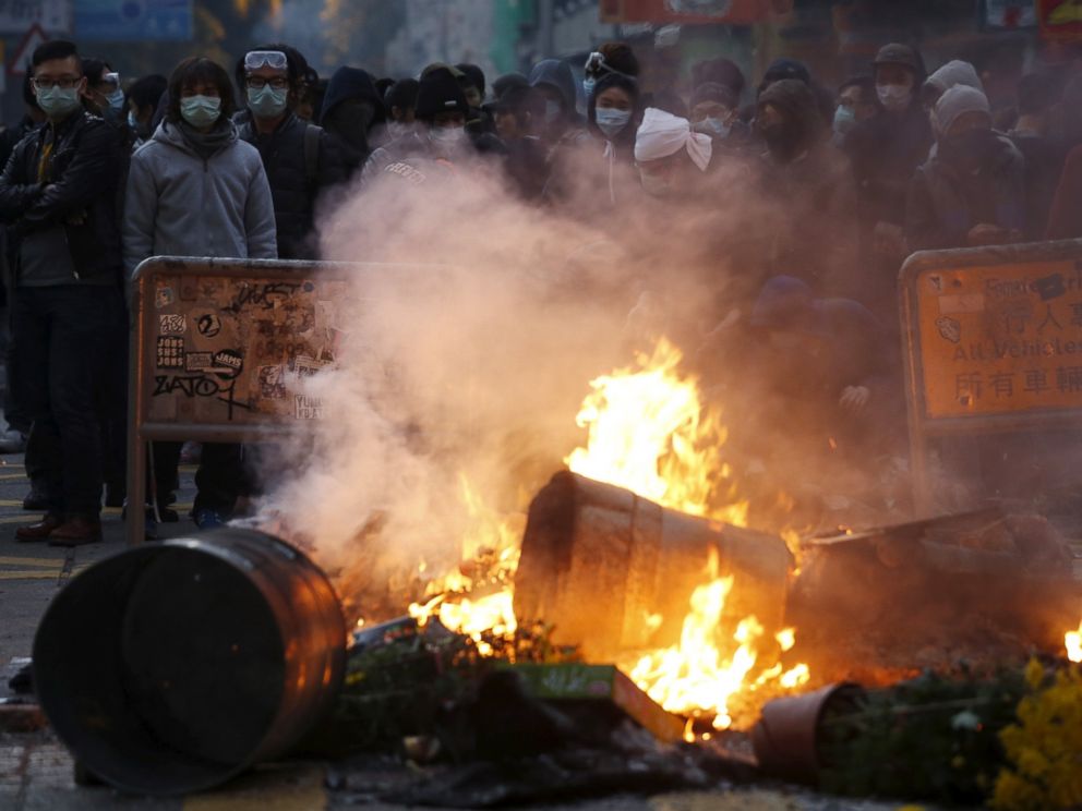 PHOTO: Protesters look on behind a fire set by them at a junction at Mongkok district in Hong Kong, Feb. 9, 2016.