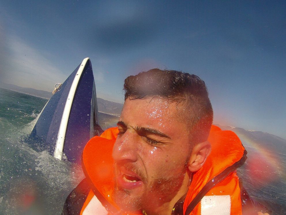 PHOTO: A migrant, identified as 20-year old Pelen Hussein from Syria, with a capsized boat in the background, as he was rescued by a member of the Turkish Coast Guard Air Command in the Aegean Sea off the waters of Edremit bay, Turkey Feb. 8, 2016.