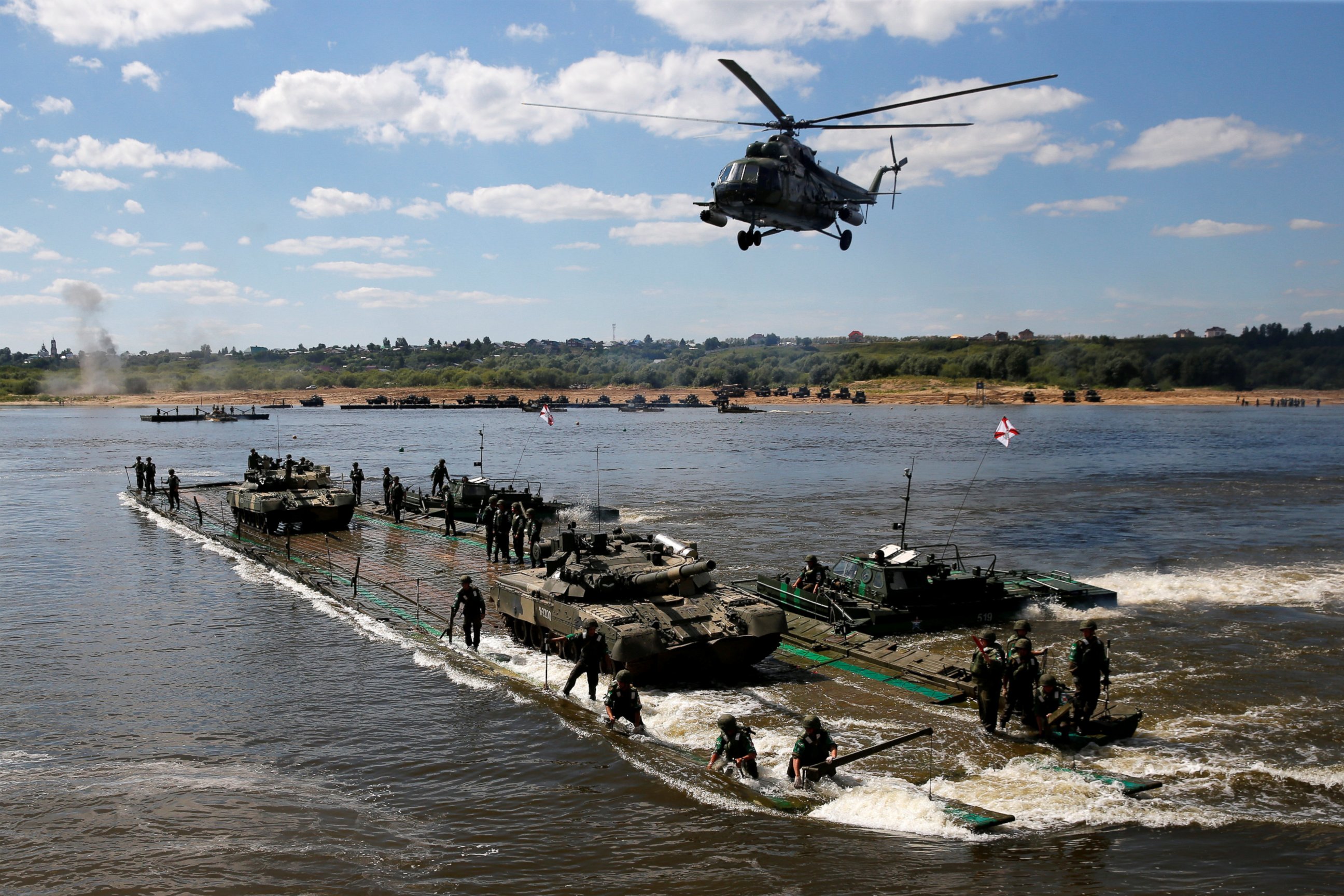 PHOTO:Russian crew members transport T-80 tanks on a pontoon bridge during the Open Water competition for pontoon bridge units, part of the International Army Games 2016, in the city of Murom, Russia, on Aug. 6, 2016. 