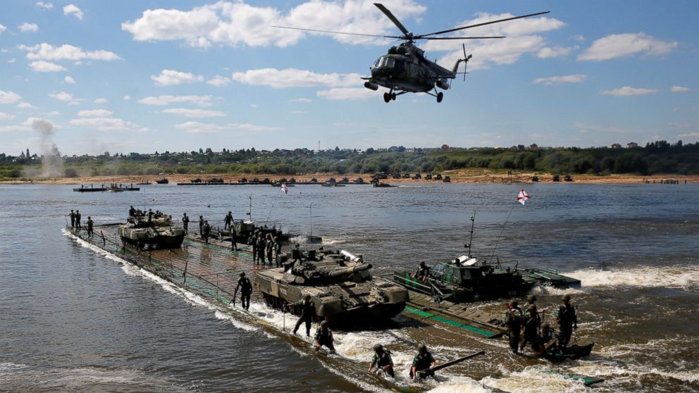 PHOTO:Russian crew members transport T-80 tanks on a pontoon bridge during the Open Water competition for pontoon bridge units, part of the International Army Games 2016, in the city of Murom, Russia, on Aug. 6, 2016. 