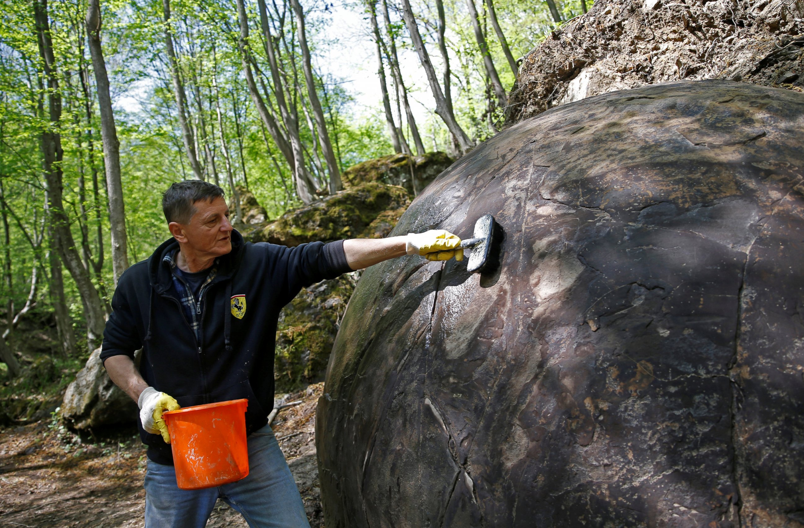 PHOTO: Suad Keserovic cleans a stone ball in Podubravlje village near Zavidovici, Bosnia and Herzegovina April 11, 2016.