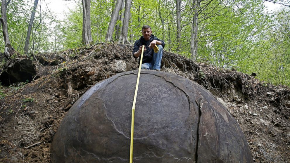 Suad Keserovic poses as he measures a stone ball in Podubravlje village near Zavidovici, Bosnia and Herzegovina, April 11, 2016. 