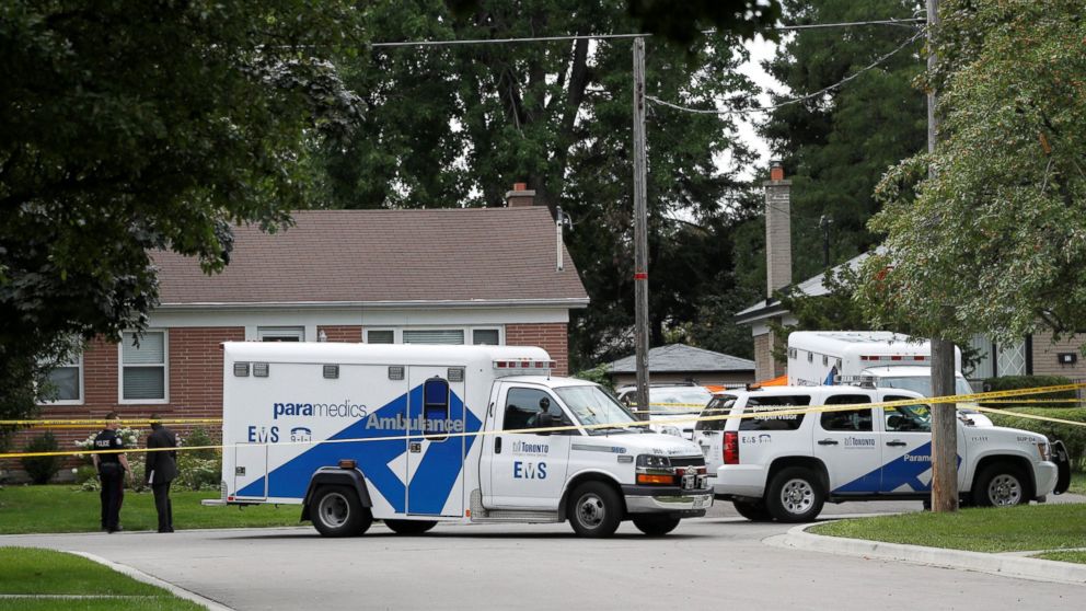 Police stand at a crime scene in front of a house where three people have died in an incident involving a crossbow in the Scarborough suburb of Toronto, Aug. 25, 2016.    