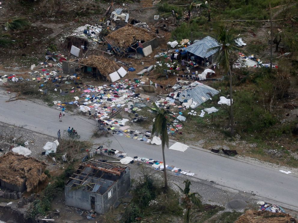 PHOTO: People walk down the street next to destroyed houses after Hurricane Matthew passes Jeremie, Haiti, Oct. 5, 2016.