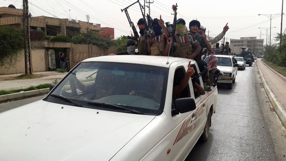 Fighters of the Islamic State of Iraq and the Levant (ISIL) celebrate on vehicles taken from Iraqi security forces, at a street in city of Mosul, June 12, 2014.