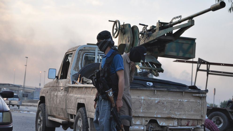 Fighters of the Islamic State of Iraq and the Levant (ISIL) stand guard at a checkpoint in the northern Iraq city of Mosul, June 11, 2014. 