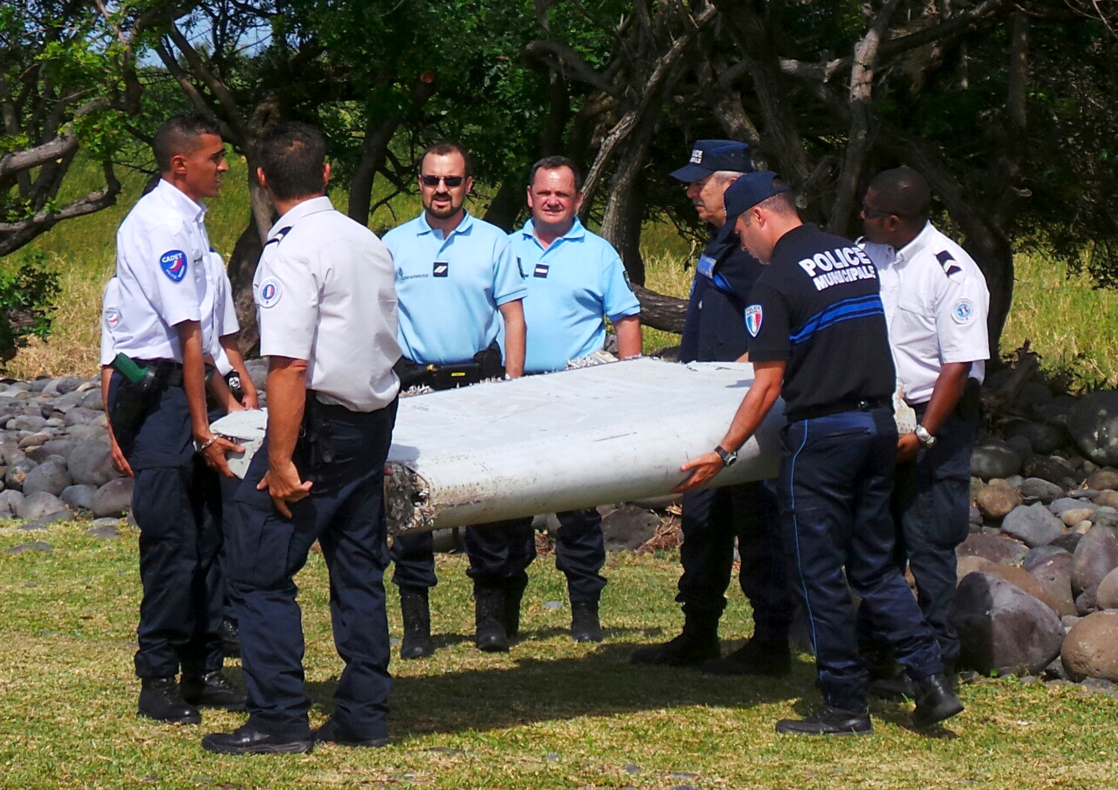 PHOTO: French gendarmes and police carry a large piece of plane debris which was found on the beach in Saint-Andre, on the French Indian Ocean island of La Reunion, July 29, 2015.