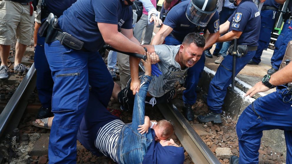 Hungarian policemen detain migrants on the tracks as they wanted to run away at the railway station in the town of Bicske, Hungary, Sept. 3, 2015.   