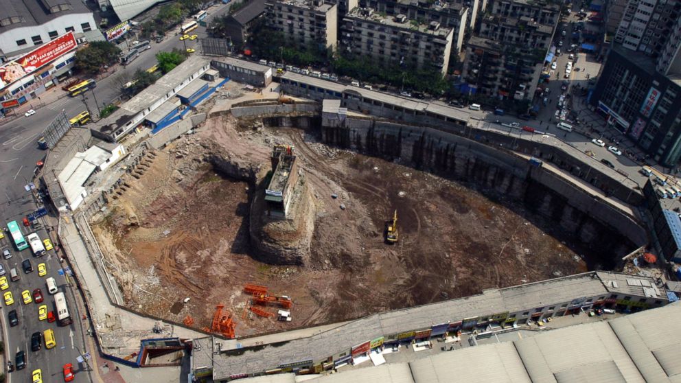 A couple, Yang Wu and Wu Ping, in Chongqing are holding out against property developers days after a court ordered them to abandon their home, the home has become an island surrounded by a construction site, as seen in this file photo, March 29, 2007.