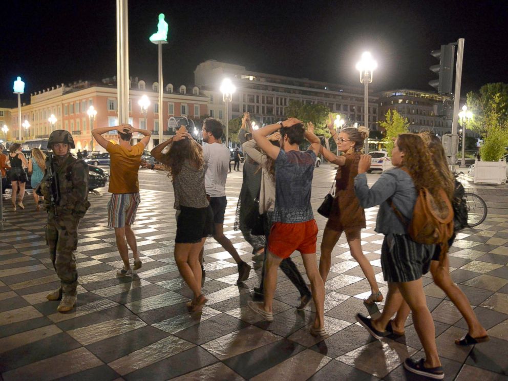 PHOTO: People cross the street with their hands on their heads as a French soldier secures the area, July 15, 2016, after a truck ran into a crowd celebrating the Bastille Day national holiday in Nice, France.  