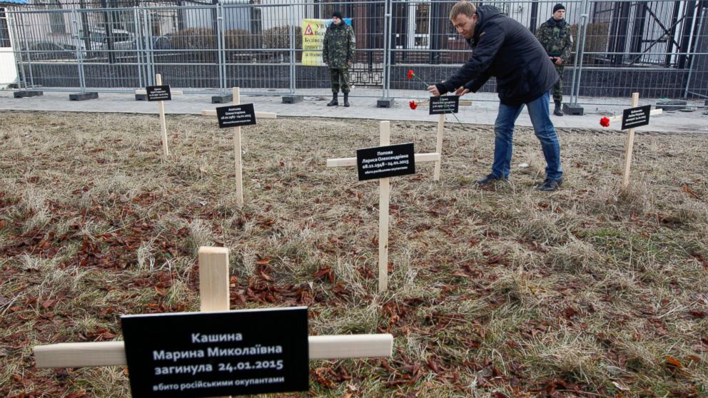 An activist places a cross with the name of a victim who was killed in shelling of the government-held port in Kiev, Feb. 1, 2015. 