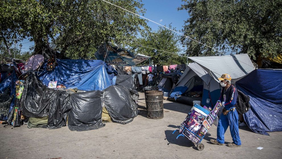PHOTO: A vendor passes in front of a makeshift migrant camp in Reynosa, Tamaulipas state, Mexico, Oct. 6, 2021.