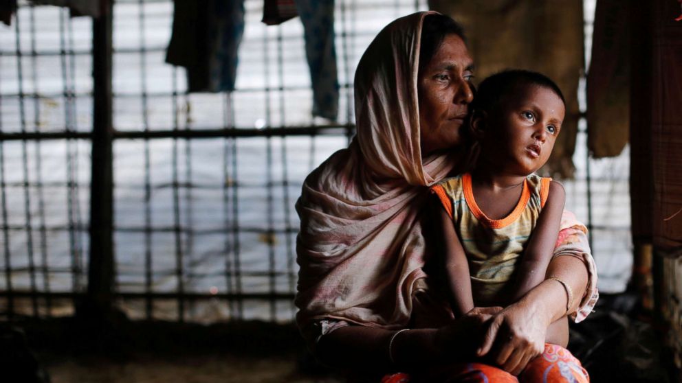 A Rohingya refugee woman waits for aid with her grandson inside their temporary shelter at a camp in Cox's Bazar, Bangladesh, Sept. 19, 2017. 