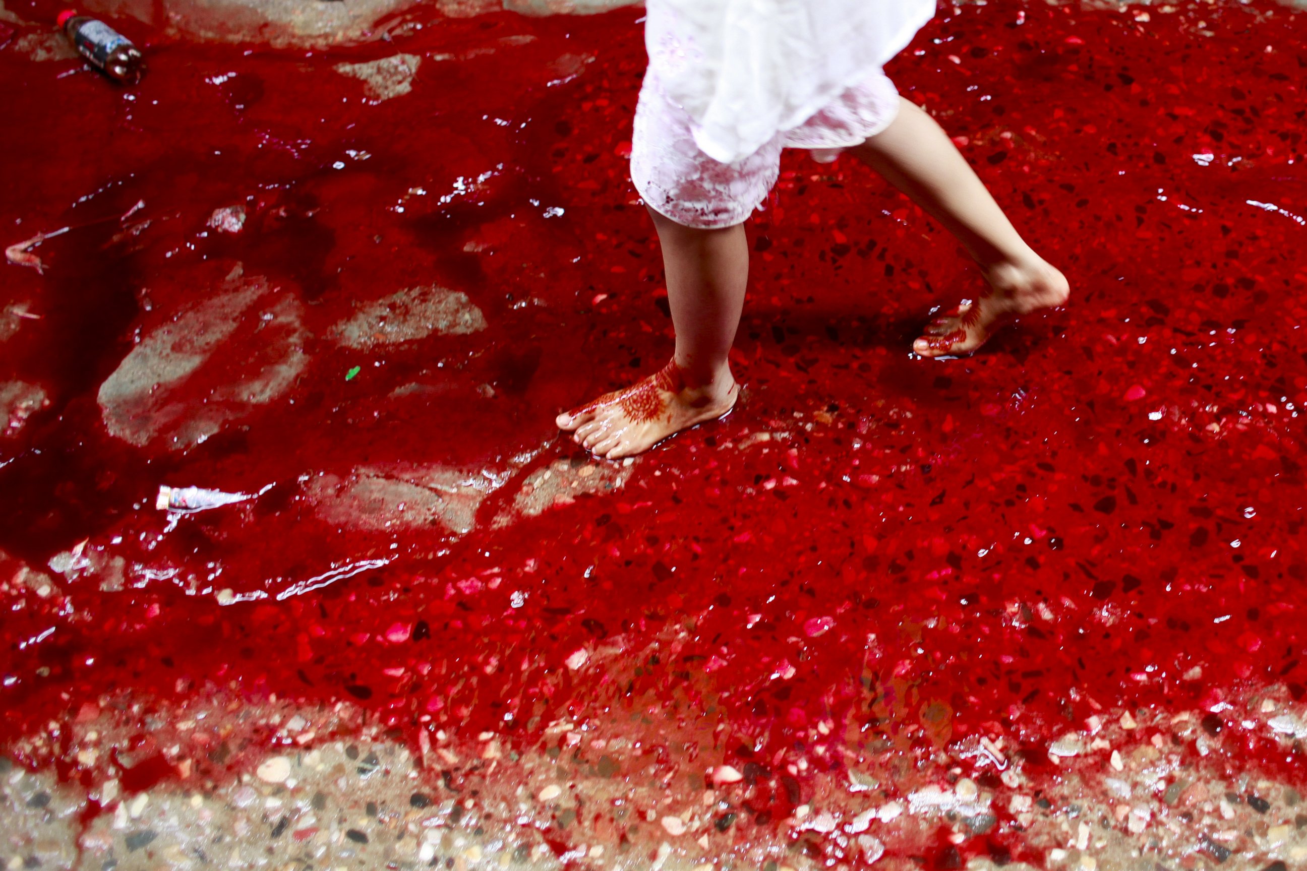 PHOTO: A Bangladeshi girl walks on a street full with blood comes from animals sacrificed for the Eid al-Adha festival in Dhaka, Bangladesh. 