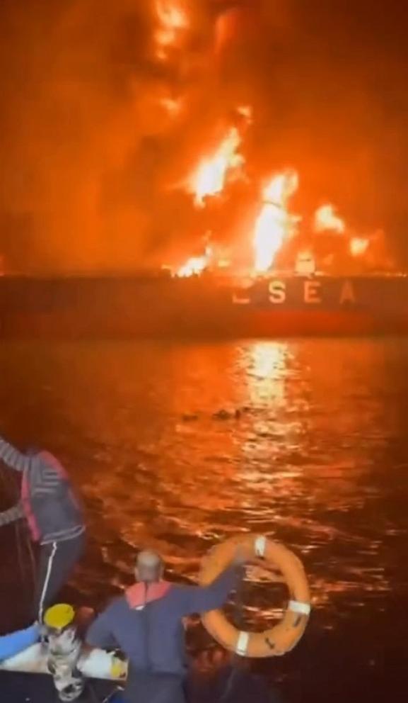 PHOTO: A screenshot from video circulating online appears to show crew from an adjacent vessel throwing rubber rings to people in the water as the tanker burns on Thursday, March 12, 2026.