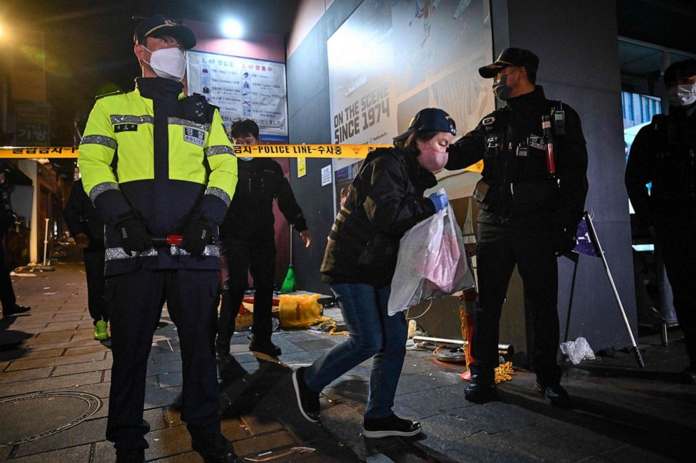 A police crime scene investigator carries a plastic bag as she walks from the alley in which a Halloween stampede took place in the neighbourhood of Itaewon in Seoul on October 30, 2022. 