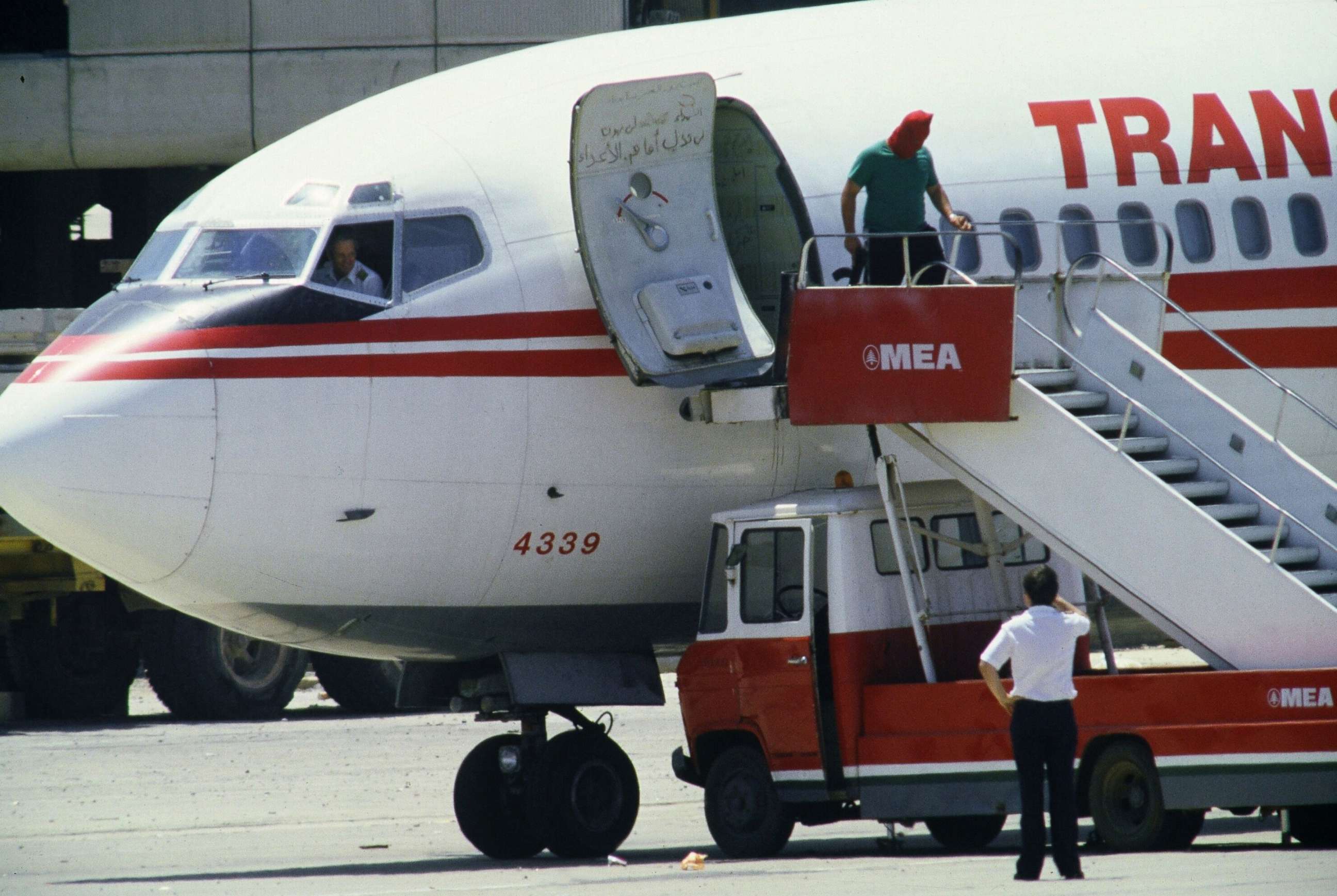 PHOTO: In this file photo taken on June 29, 1985, TWA Boeing 727 captain John L. Testrake from Richmond, Missouri, emerges from the cockpit of his hijacked airliner at Beirut airport while a Shiite masked gunman holding a machine-gun leaves the plane.
